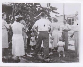 Group of men and women with little children.