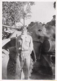 Soldier standing in front of armoured car