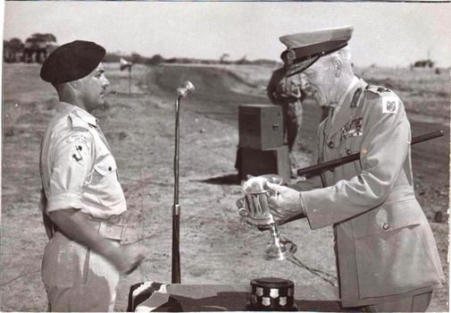 Two officers with a presentation cup.