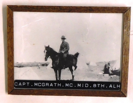 Soldier on horse near tents.