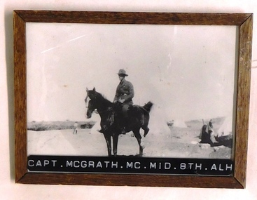 Soldier on horse near tents.