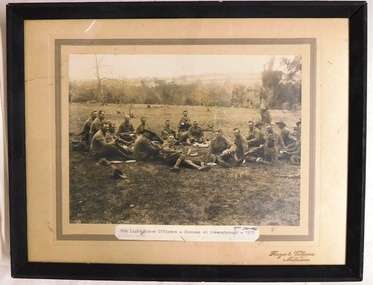 Framed photograph of soldiers relaxing in paddock