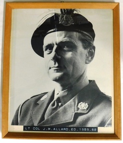 Portrait of soldier wearing beret with plumes behind badge.