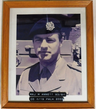 Framed photograph of army officer wearing beret.