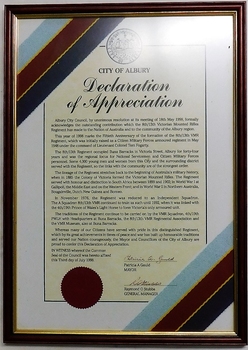 Decorated coloured document in frame.