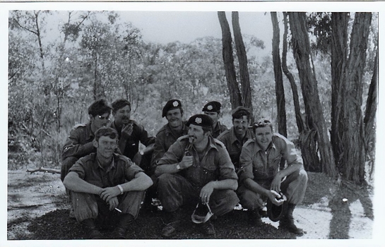 eight soldiers resting in bushland.