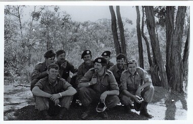 eight soldiers resting in bushland.