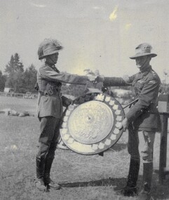 Two soldiers with large trophy shield.