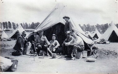 Soldiers outside a tent among many other tents