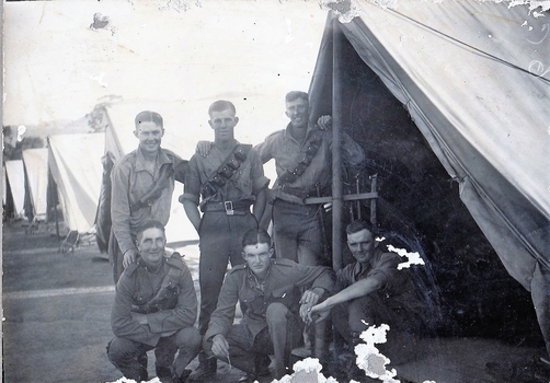 Six soldiers with row of tents.