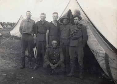 Six soldiers outside a tent.