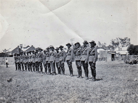 Line of soldiers with buildings in background