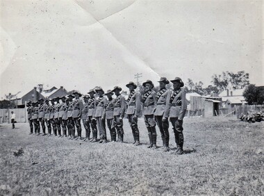 Line of soldiers with buildings in background