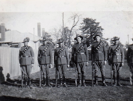 Six soldiers with rifles in paddock