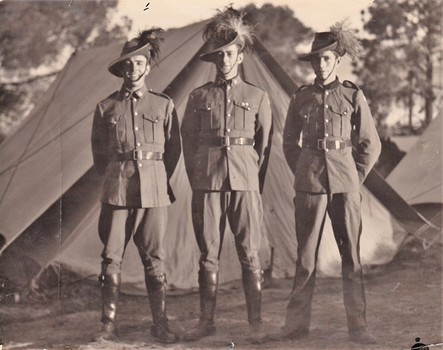 Three soldiers standing in front of tent