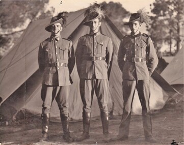 Three soldiers standing in front of tent