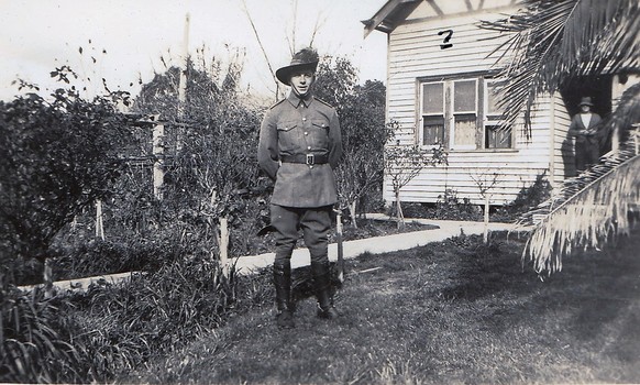 Soldier standing in front of farmhouse