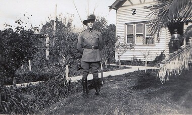 Soldier standing in front of farmhouse