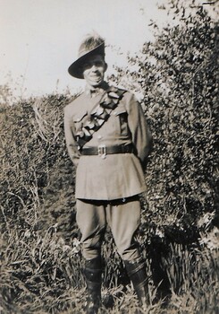 Soldier smiling standing near small tree