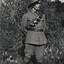 Soldier in uniform standing near tree.