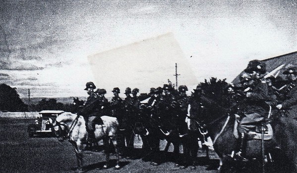 Soldiers on horses near car