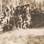 Soldiers without shirts near tracked vehicle