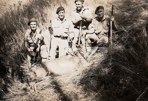 Soldiers wearing berets with rifles