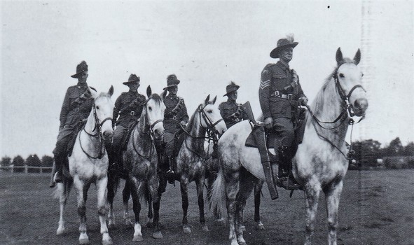 Five soldiers armed with rifles on horses
