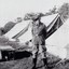 Soldier standing beside row of tents.