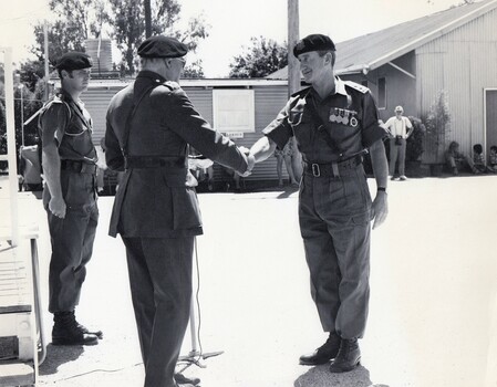Three soldiers, two are shaking hands