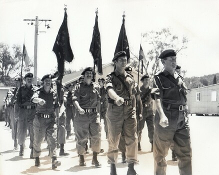 Soldiers marching with flags.
