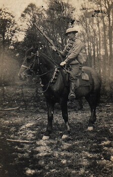 Soldier holding rifle on horseback