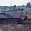 Tracked army vehicle with hills in background.