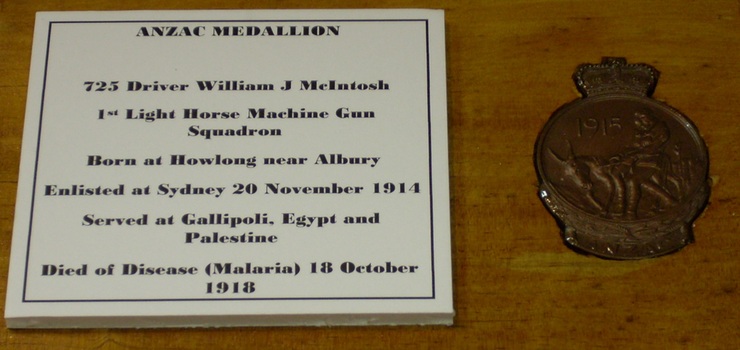 Small medallion fixed to a wooden block