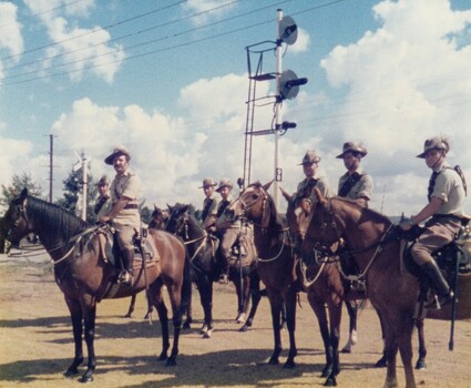 Soldiers on horses at railway warning lights