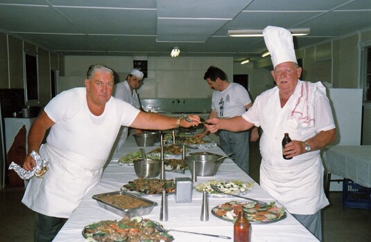 Two army cooks preparing food