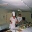 Army cooks making final adjustments to meal.