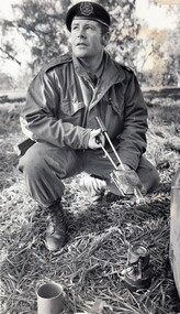 Soldier cooking with a jaffle iron and a small camp stove.