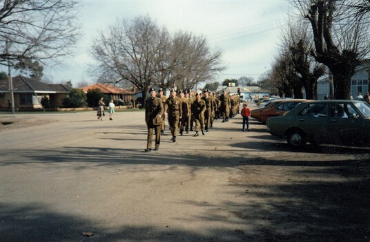 Large group of soldiers marching in town street