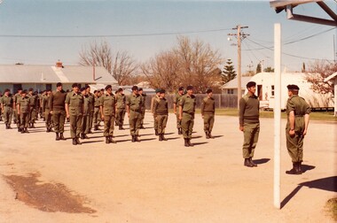 Soldiers lined up near barrack buildings