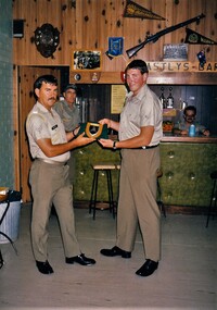 Two soldiers in a recreation room making a presentation.