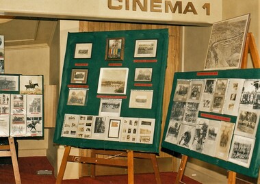 Display boards with many photographs attached.