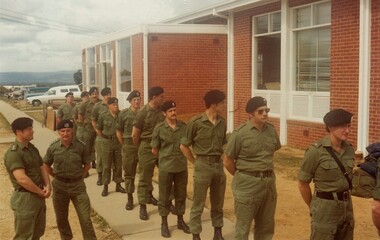 Line of soldiers beside brick building