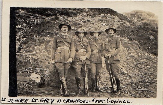 Four army officers standing against an earth bank.