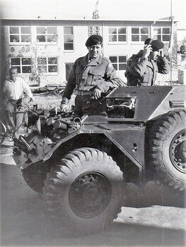 Two soldiers with an armoured vehicle.