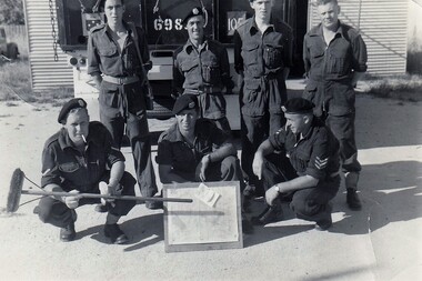 Group of soldiers, one with broom
