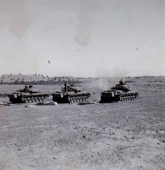 Tanks in paddock firing guns
