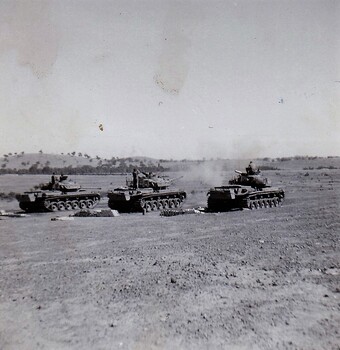 Tanks in paddock firing guns