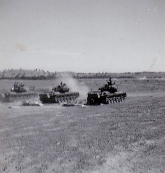 Tanks in paddock firing guns