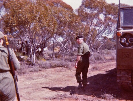 Two soldiers near vehicles in bushland